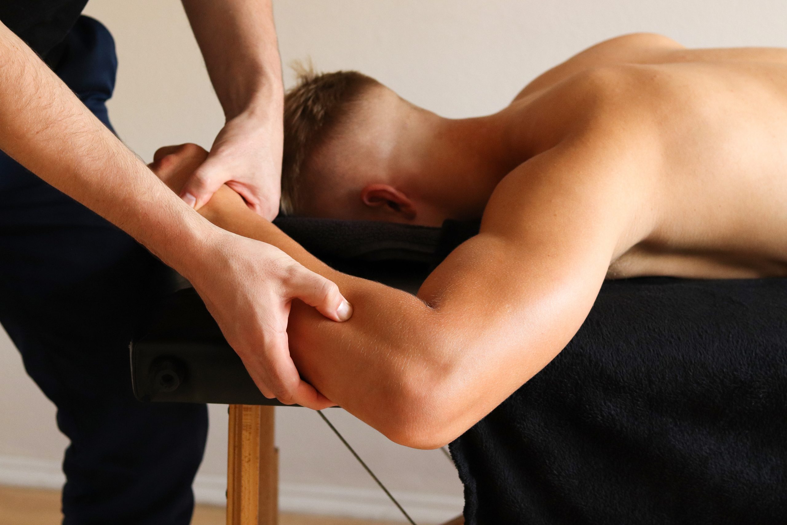 Masseur does hands massage in spa center. Massage of myofascial trigger points on hand of male client to release tension. Rehabilitation, sport therapy medicine.